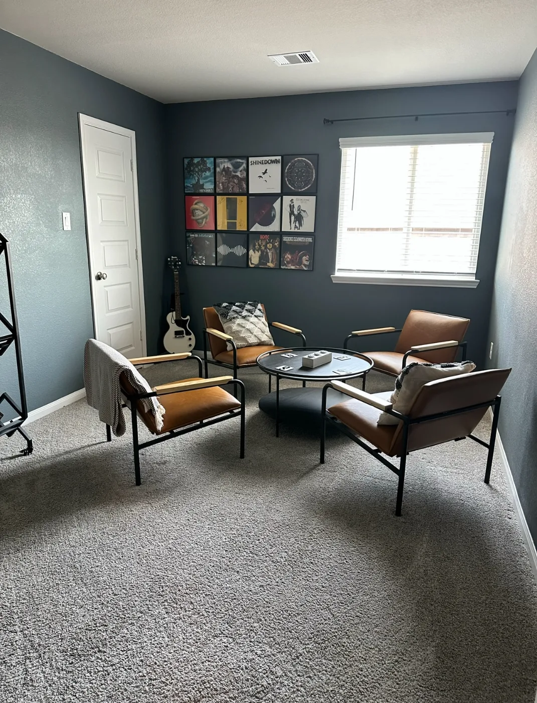 Den with vacuumed carpet and dusted furniture