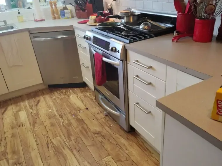 Kitchen wood floors cleaned around the range and cabinets