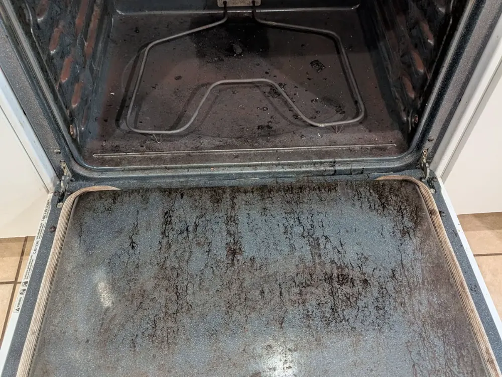 Oven caked with burnt-on grease before cleaning